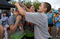 Einer unserer Helfer beim M-net Firmenlauf Augsburg bei der Medaillenvergabe